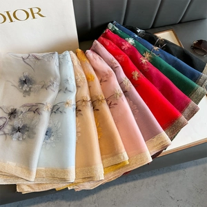 Detailed embroidery on colorful lightweight tulle scarves with golden metallic thread edges