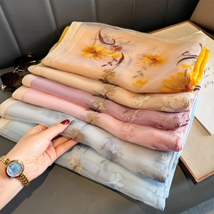 Detailed close-up of premium sheer silk scarves with 3D floral embroidery in pastel tones