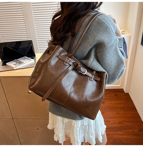 Détail du sac cabas rétro marron foncé avec boucle latérale et texture en cuir brillant