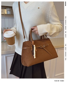 Brown frosted leather tote detail showing ethnic tassels and elegant buckle strap design