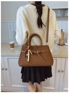 Detail of dark brown faux suede tote bag with wood bead charm and adjustable strap