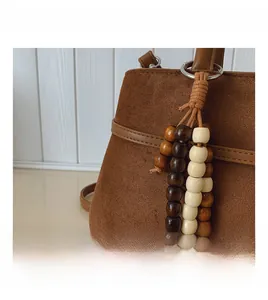 Detail of dark brown faux suede tote with beaded tassel and wood accents