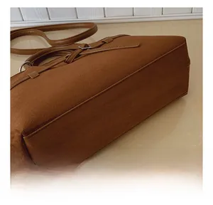 Detailed view of the refined stitching and soft suede texture of the brown tote bag