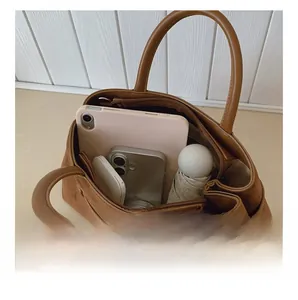 Detail view of large brown suede tote bag showing spacious interior for tablets and phones