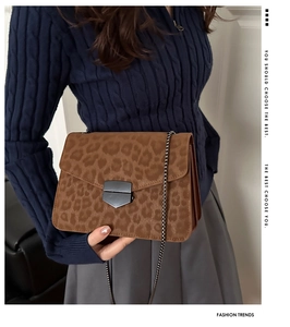 Detail showing leopard print texture, chain strap and metallic lock on crossbody bag