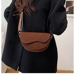 Sac selle en daim marron avec rabat ondulé et large bandoulière en maille sur mannequin