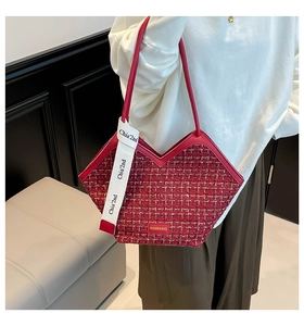 Close-up of burgundy tweed tote bag featuring chic white logo straps and leather trim
