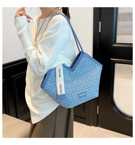 Detail of blue tweed tote bag with V-shaped opening and decorative fashion straps