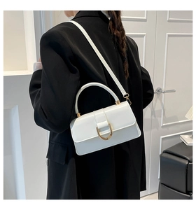 Close-up of white PU leather crossbody bag with a distinctive gold D-ring buckle closure