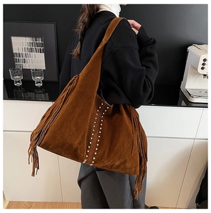 Detailed view of brown fringe tote bag with silver studs and matte suede-like texture