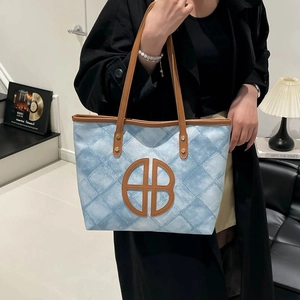 Large capacity tote bag with blue diamond pattern and brown leather straps in casual setting