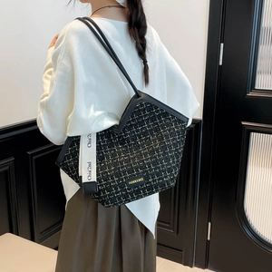 Fashionable tweed tote bag with leather straps and decorative ribbon for daily commute