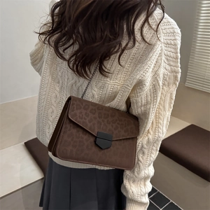 Retro leopard print crossbody bag with metal chain strap shown on a model side view