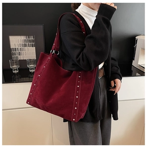 Détail du grand sac cabas en daim bordeaux avec rivets argentés et bandoulière spacieuse