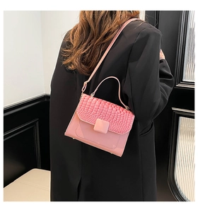 Pink crocodile pattern leather handbag shown on a model with a black blazer