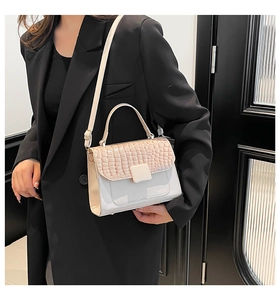 Detail of a beige contrast handbag with faux crocodile flap and adjustable strap