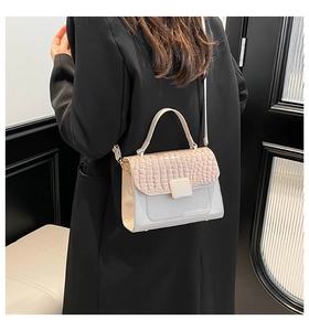 Detail of off-white crossbody bag with crocodile pattern flap and smooth texture finish