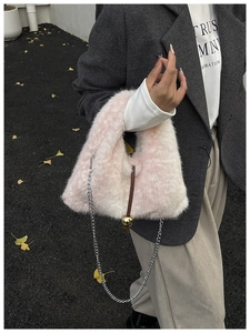Detail of pink and white plush bucket bag with silver chain and gold sphere charm