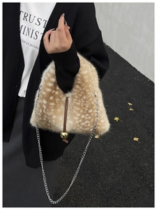 Detail of deer print faux fur bag featuring gold metal ball charm and chain strap