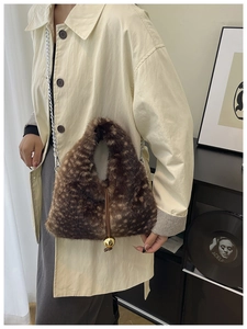Detailed view of plush leopard print faux fur bag with golden metal ball and chain strap