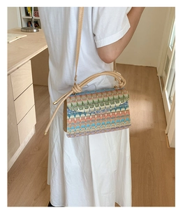 Detail of colorful woven shoulder bag with geometric patterns and leather strap