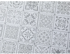 Detail of laser-cut PET stencils featuring symmetrical mandala and floral patterns