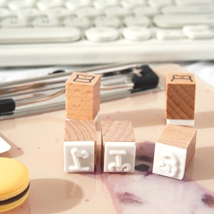 Five-piece wooden letter B and bear stamps set on a pink desk mat for DIY scrapbooking