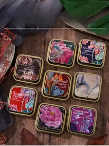 Flat lay of vintage tin ink pads with botanical patterns on a rustic wooden desk