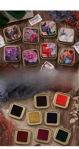 Detail of 8-color vintage ink pad set in round metal boxes with floral illustrations
