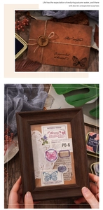 Close-up of vintage butterfly stationery set with wax-sealed envelope and antique frame