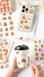 Macro detail of cartoon guinea pig stickers on a coffee cup and creative stationery