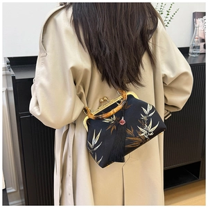 Elegant bamboo handle qipao bag featuring bamboo leaf embroidery and a long black tassel