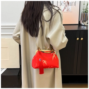 Detail of red Chinese style satin bag with bamboo handle and elegant long tassels