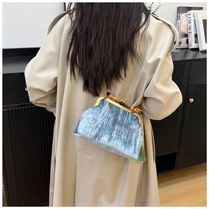 Detail of vintage blue velvet handbag with bamboo handle and elegant tassel decoration