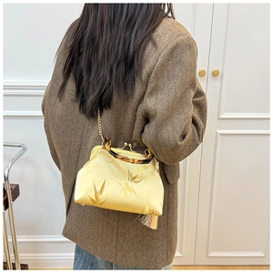 Detail of elegant silk bamboo pattern bag with bamboo handle and golden tassel