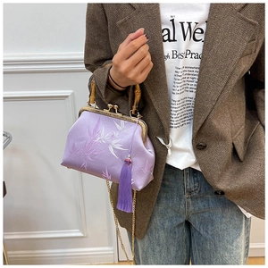 Detailed shot of purple silk qipao bag with bamboo handle and elegant leaf embroidery
