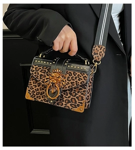 Close-up of leopard print bag featuring gold lion head buckle and studded metal edges