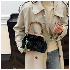 Detail of black velvet bag with bamboo handle, leaf embroidery and silk tassel