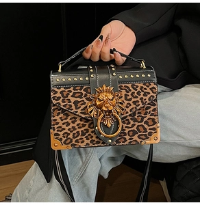 Detail of leopard print handbag with gold lion head hardware and stud accents