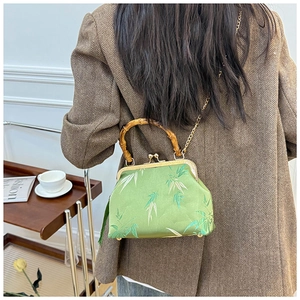 Detail of green silk bamboo pattern bag with authentic bamboo handle and gold chain