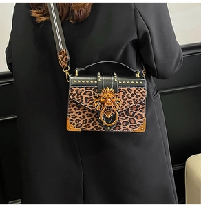 Detail of leopard print crossbody bag with gold lion head buckle and studded edge decoration