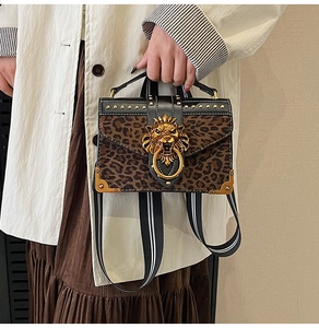Detailed close-up of leopard print handbag with golden lion head and rivet detailing