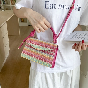 Colorful woven handbag with pink leather handle and adjustable shoulder strap for women
