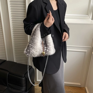 Faux fur bucket bag with spotted texture and gold sphere charm on silver chain strap