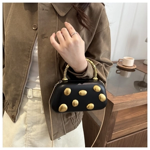 Detail einer schwarzen Lederhandtasche mit goldenen Kieselsteinen und Spiralgriff-Design