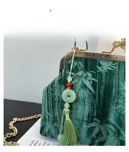 Detailed view of green velvet handbag featuring bamboo texture and elegant silk tassel