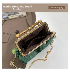 Detail view of emerald velvet bag with bamboo handle, gold clasp and brown inner lining