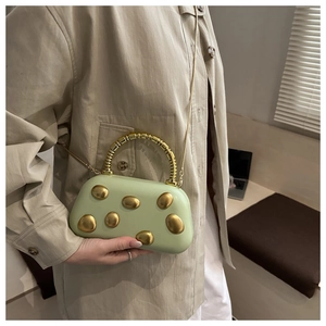 Detail der hellgrünen Abendtasche mit matten Goldakzenten und Perlen Griff Design