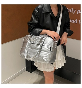Bolso tote acolchado plateado con acabado metálico mostrado en modelo para uso diario