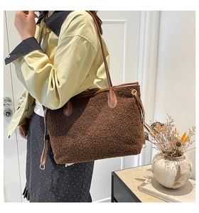 Brown fuzzy plush tote bag with leather straps and drawstring detail in a lifestyle setting